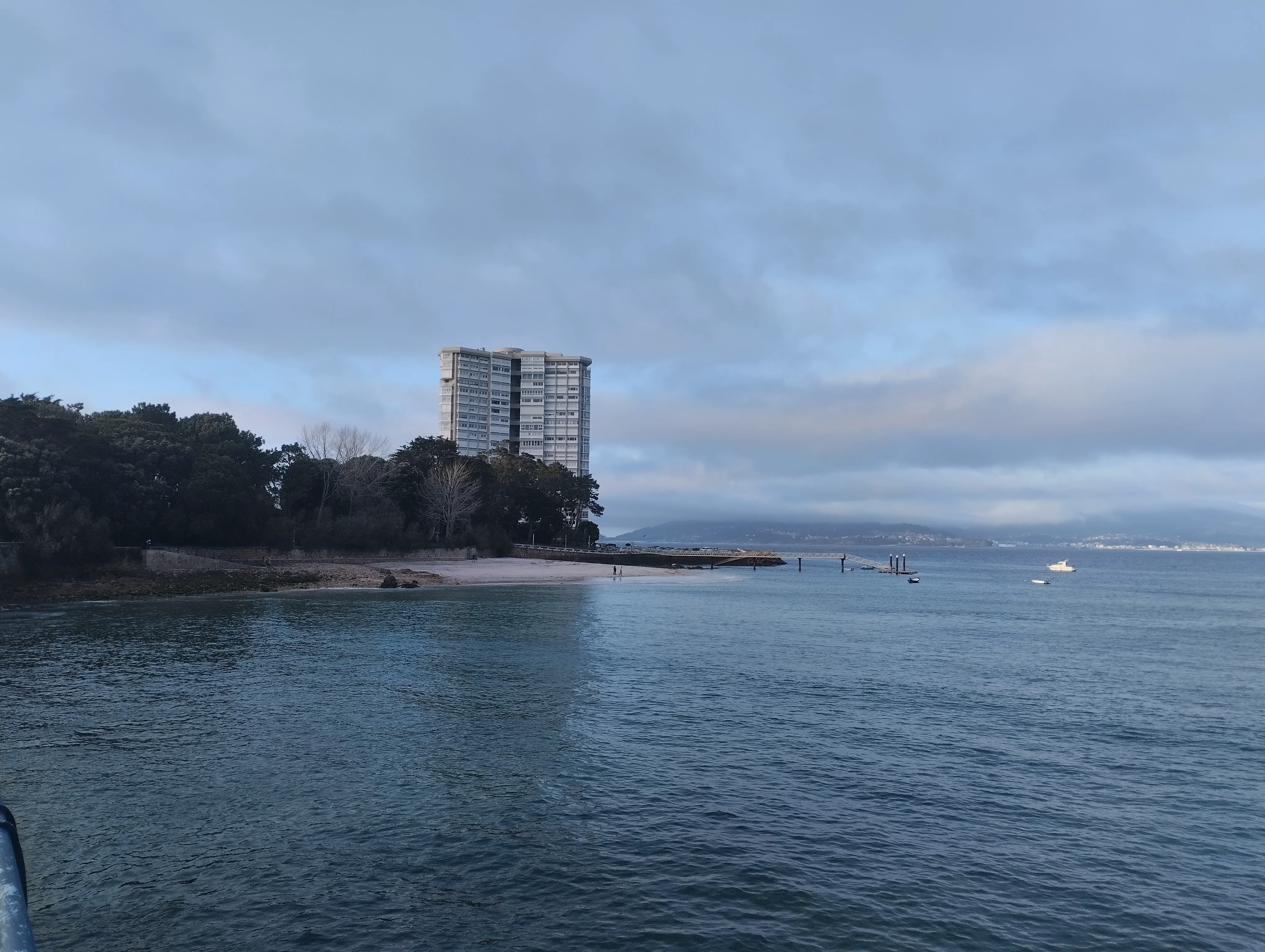 Vista de la playa pública de la isla, con la torre de viviendas al fondo
