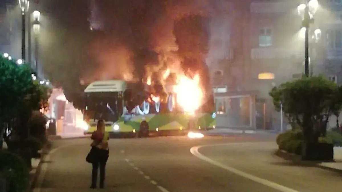 El autobús 6806 de Vitrasa ardiendo, mientras su conductora, lo observa. Imagen: Faro de Vigo